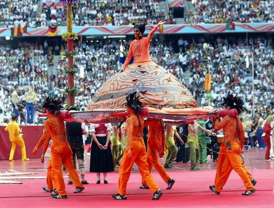 Eröffnungsfeier zur WM 2006 - Verkleidete junge Dame im riesigen Rock wird hineingetragen Fußball WM Herren WM 2006, Eröffnung, Feier, Eröffnungsfeier, Zeremonie, Eröffnungszeremonie Gruppe München Freude, Fußball WM Herren WM 2006, Eröffnung, Feier, Eröffnungsfeier, Zeremonie, Eröffnungszeremonie Gruppe München Freude,