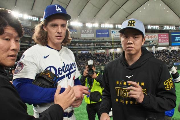 Los Angeles Dodgers pitcher Tyler Glasnow(C) speaks with Hanshin Tigers pitcher Hiroto Saiki(R) after the MLB, Baseball Herren, USA Tokyo Series, exhibition game at Tokyo Dome in Tokyo, Japan on Sunday, March 16, 2025. TKP2025031619 KEIZOxMORI