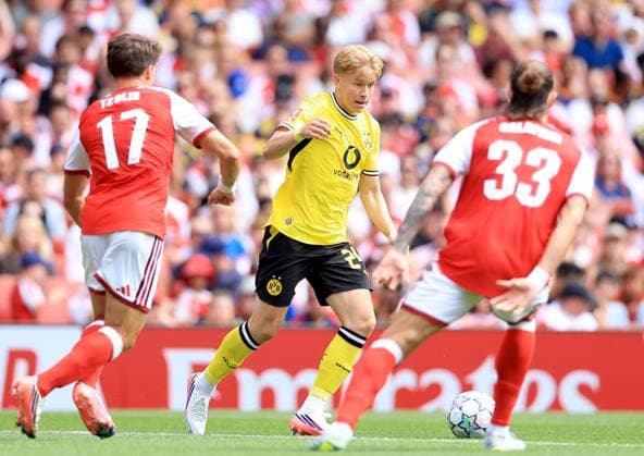 Daniel Svensson of Borussia Dortmund in action against Christos Tzolis (left) and Riccardo Calafioli of Arsenal Arsenal v Borussia Dortmund, Pre Season Friendly, Football, Emirates Stadium, London, UK - 09 Aug 2026London Emirates Stadium United Kingdom EDITORIAL USE ONLY No use with unauthorised audio, video, data, fixture lists, club league logos or live services. Online in-match use limited to 120 images, no video emulation. No use in betting, games or single club league player publications. Copyright: xGeorgexTewkesbury Shutterstockx 17051143v