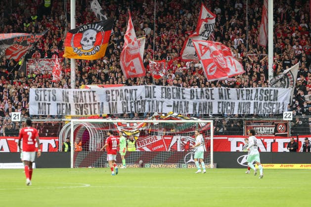 20.09.2026, xtgx, Fussball 2. Bundesliga, FC Energie Cottbus - FC St. Pauli, v.l. Symbolfoto, Symbolbild, Symbol Fans, Zuschauer, Publikum, Tribuene Spruchband Banner Stets in Watte gepackt, die eigene Blase nie vberlassen. Mit dem System im Gleichtakt - man kann euch nur hassen (DFL DFB REGULATIONS PROHIBIT ANY USE OF PHOTOGRAPHS as IMAGE SEQUENCES and or QUASI-VIDEO) Cottbus