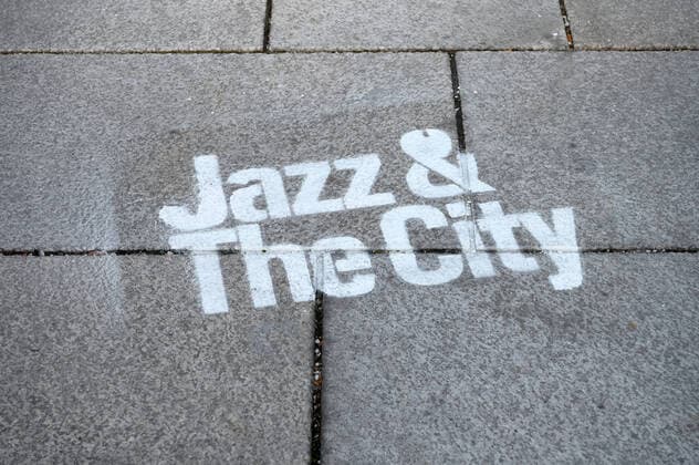 Musikexperiment des Architekten, Musikers, Komponisten und Theoretikers Christopher Dell, im Rahmen der Veranstaltungsreihe Jazz & The City , am 17.10.2019, in Salzburg (Galerie 5020), Österreich. Das Bild zeigt einen auf dem Boden vor der Galerie aufgesprayten Schriftzug der Veranstaltungsreihe 2019 - Musikexperiment des Architekten, Musikers, Komponisten und Theoretikers Christopher Dell, im Rahmen der Veranstaltungsreihe Jazz & The City , im Galerie 5020 in Salzburg, am 17.10.2019.