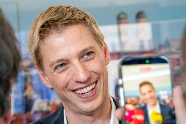 Dominik Krause, DIE GRÜNEN, neuer Müchner Oberbürgermeister, Amtsantritt: erster Arbeitstag im neuen OB-Büro im Rathaus, gibt Presseinterviews, München, 4. Mai 2026 Deutschland, München, Dominik Krause, DIE GRÜNEN, neuer Müchner Oberbürgermeister, Amtsantritt: erster Arbeitstag im neuen OB-Büro im Rathaus, empfängt Journalisten zu Fotos und Interviews, im Hintergrund ein München-Foto mit dem Wahrzeichen Frauenkirche, Kommunalpolitik, Bayern
