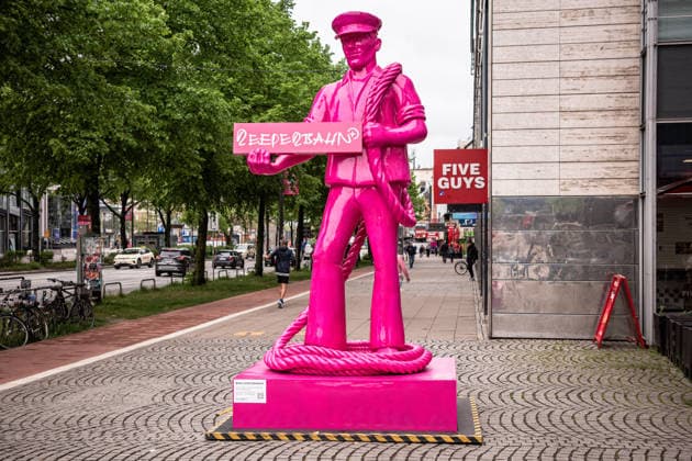 Deutschland, Hamburg, Reeperbahn 400 Jahre Jubiläum, pinke Seemanns-Statue, temporäre Kunstinstallation, ca. 4 Meter hoch, ca. 350 kg schwer, Figur mit Reepe (Tau) über der Schulter, Seemannshut, erinnert an Reepschläger des 17. Jahrhunderts, Herstellung von bis zu 300 Meter langen Tauen, Namensherkunft der Reeperbahn (früher Altonaer Allee), Ausstellung bis Anfang Oktober, urbaner Straßenraum, moderner Kontext trifft historische Bedeutung Copyright: xStefanxTrochax