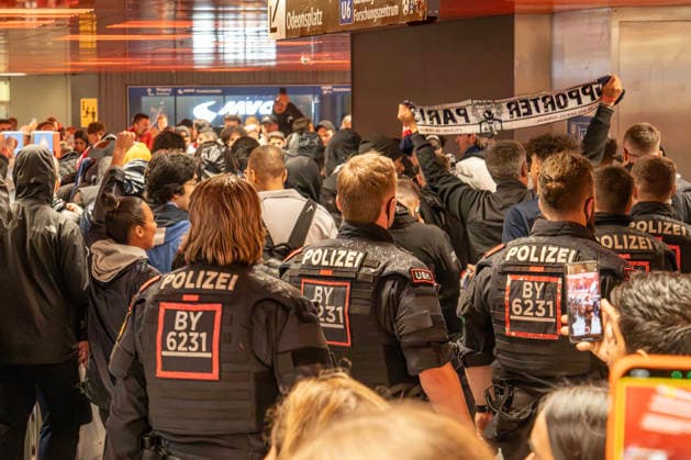 Polizisten begleiten französische Fußballfans im U-Bahnhof Zwischengeschoss Marienplatz, PSG-Fans fahren mit der U3 zum Champions-League Halbfinale FC Bayern München gegen Paris Saint-Germain in der Allianz Arena, München, 6. Mai 2026 Deutschland, München, 6. Mai 2026, Polizisten begleiten lautstarke französische Fußball-Fans im U-Bahnhof Zwischengeschoss Marienplatz, PSG-Fans fahren mit der U3 zum Champions-League Halbfinale FC Bayern München gegen Paris Saint-Germain heute Abend, Polizei sorgt für Sicherheit im U-Bahnhof Marienplatz, Fußballspiel, Sport, Fußball, Bayern