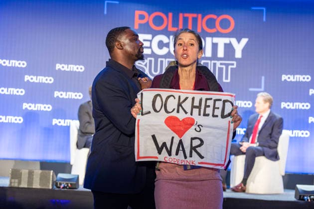 May 12, 2026, Washington, District Of Columbia, USA: A protester holds a sign and shouts against the war at the POLITICO Security Summit on Tuesday, May 12, 2026, in Washington, D.C., a Lockheed Martin-sponsored event, during a discussion featuring Rep. Adam Smith and Rep. Michael R. Turner, who were speaking about the Iran war and President Donald Trumpâ€⠢s approach. The protester was removed from the room by security staff. Washington USA - ZUMAkh2_ 20260512_znp_kh2_033 Copyright: xAlixKhalighx