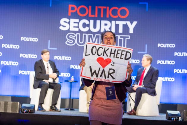 May 12, 2026, Washington, District Of Columbia, USA: A protester holds a sign and shouts against the war at the POLITICO Security Summit on Tuesday, May 12, 2026, in Washington, D.C., a Lockheed Martin-sponsored event, during a discussion featuring Rep. Adam Smith and Rep. Michael R. Turner, who were speaking about the Iran war and President Donald Trumpâ€⠢s approach. The protester was removed from the room by security staff. Washington USA - ZUMAkh2_ 20260512_znp_kh2_034 Copyright: xAlixKhalighx