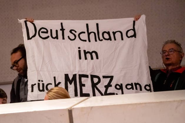 Deutschland im rückMERZgang, Protest gegen Bundeskanzler Friedrich Merz, CDU, während seines Gesprächs mit jungen Menschen, Podiumsdiskussion, Congress Centrum, 104. Deutscher Katholikentag, Würzburg, 15. Mai 2026 Deutschland, Würzburg, 15. Mai 2026, Deutschland im rückMERZgang, Protest im Frankonia Saal während des Auftritts von Bundeskanzler Friedrich Merz, CDU, im Gespräch mit jungen Menschen, Podiumsdiskussion unter dem Motto: Gemeinsam Zukunft gestalten, Congress Centrum, Franconia Saal, 104. Deutscher Katholikentag, das Motto des Kirchentags lautet: Hab Mut, steh auf!, katholische Kirche, Demokratie, Jugend, Bayern