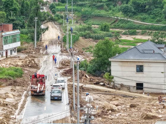 (260526) -- CHONGQING, May 26, 2026 -- A drone photo taken on May 26, 2026 shows staff members of State Grid Chongqing Yongchuan Power Supply Company repairing power supply lines at Anxi Village of Yongchuan District, southwest China s Chongqing Municipality, May 26, 2026. From Saturday night to early Sunday morning, a sudden and extreme catastrophic rainstorm struck Yongchuan, triggering flash floods and geological disasters in multiple areas of this district. After the disaster occurred, the local authorities immediately activated the emergency response mechanism, coordinated rescue forces from all sides and made every effort to carry out rescue operations and infrastructure restoration. Rescue and response efforts are still under