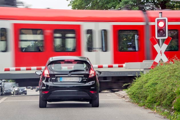Münchner S-Bahn passiert beschrankten Bahnübergang, Andreaskreuze blinken rot, Zug fährt durch, Ottobrunn bei München, 30. Mai 2026 Deutschland, Ottobrunn bei München, Mai 2026, beschrankter Bahnübergang, S-Bahn der Linie S7 nach München fährt durch, Andreaskreuze blinken rot, Autos warten vor der Schranke, mittags, Öffentlicher Nahverkehr, ÖPNV, Verkehr, Landkreis München, Bayern, Münchner Umland,