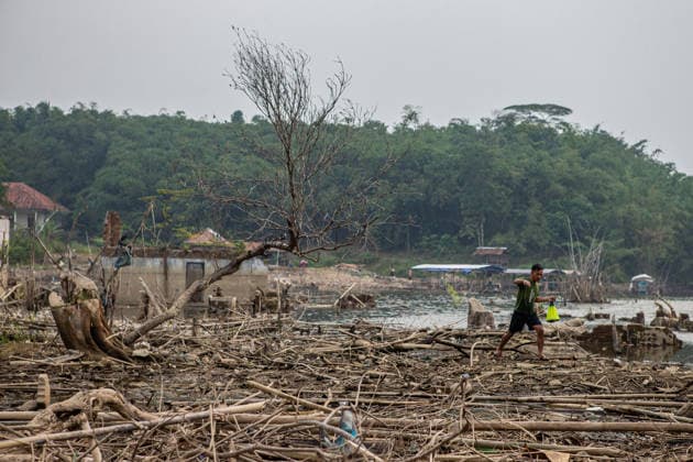 July 31, 2026, Lebak Regency, Banten, Indonesia: A man carries a fishing net as he walks through the ruins of Somang village, which has re-emerged as water levels recede during the dry season, amid forecasts that El Nio±o may contribute to drier-than-normal conditions, at Karian Reservoir in Sajira district, Lebak Regency, Banten province, Indonesia, July 31, 2026. Lebak Regency Indonesia - ZUMAp283 20260731_zip_p283_019 Copyright: xClaudioxPramanax