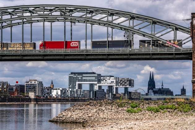 Niedrigwasser im Rhein bei Köln, Blick vom rechtsrheinischen Ufer über die Poller Wiesen, Richtung Norden, Südbrücke, Eisenbahnbrücke, Frachtzug, Skyline der Innenstadt mit dem Dom, die Binnenschifffahrt ist stark eingeschränkt, nur wenige Schiffe fahren, dann mit stark reduzierter Ladung, am Tag der Aufnahme war es bis dato der tiefste je gemessener Rheinpegel in Köln, 60 cm, NRW, Deutschland Niedrigwasser Rhein K