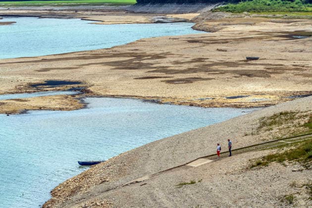 Der Wasserspiegel des Sylvensteinspeichers ist wegen anhaltender Trockenheit deutlich gesunken, breite Uferstreifen sind trocken gefallen, das Niedrigwasser sorgt für breite Kiesflächen, Bayerische Alpen, Lenggries, 7. August 2026 Deutschland, Lenggries-Fall, 7. August 2026, breite Kiesflächen am Ufer des Sylvensteinspeichers, die anhaltende Trockenheit hat den Wasserspiegel des Sylvensteinspeichers deutlich sinken lassen, breite Uferstreifen sind trocken gefallen, Niedrigwasser sorgt für einen breiten Kiesstrand, Spaziergänger am Ufer, künstlicher Speichersee in den Bayerischen Voralpen bei Lenggries, Wasserspeicher zur Regulierung der Isar, Hochsommer, heißer Sommertag, Freitagnachmittag, Landkreis Bad Tölz-Wolfratshausen, Oberba