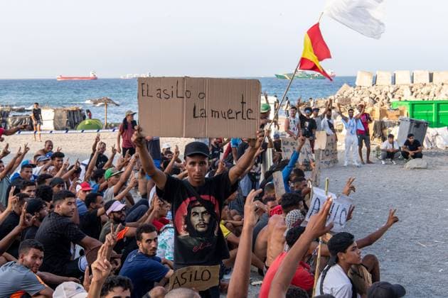 August 17, 2026, Ceuta, Spain: CEUTA, SPAIN †AUGUST 17, 2026: More than 100 migrants, most of them Moroccan, have been protesting for days in front of National Police vans during the daily food distribution provided by the Spanish Red Cross at TrampoloÂn Beach. â€oeNo asylum, no food†is the chant repeated by the migrants on the sand, while African migrants continue to stay in the temporary accommodation facilities set up on the Ceuta beach. Authorities are expected to clear the beach in the coming days and transfer the migrants to four reception facilities announced today by Spainâ€⠢s Minister for Migration, Elma Saiz. Ceuta Spain - ZUMAq101 20260817_zna_q101_078 Copyright: xAntonioxSemperex