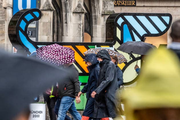 Auch der Riesen-Dackel Waldi, der für die Münchner Olympiabewerbung wirbt, steht im Regen, Passanten eilen mit ihren Regenschirmen über den Marienplatz, Starkregen am Mittwochnachmittag, München, 16. September 2026 Deutschland, München, 16. September 2026, auch der Riesen-Dackel Waldi, der für die Münchner Olympiabewerbung wirbt, steht im Regen, Passanten eilen mit ihren Regenschirmen über den Marienplatz, die überlebensgroße Figur ist an das Münchner Olympia-Maskottchen von 1972 angelehnt, am 26. September entscheidet der Deutsche Olympische Sportbund, welche deutsche Stadt ins Rennen um die Olympiade 2036, 2020 oder 2044 geschickt wird, Olympia, Olympia-Waldi, Sport, Bayern