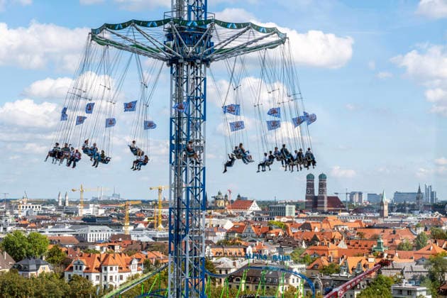 Oktoberfest 2026, Blick vom Riesenrad auf den BayernTower, am Horizont die Stadt München mit ihrem Wahrzeichen der Frauenkirche, Wiesn-Start bei strahlendem Sonnenschein und Temperaturen bis 24 Grad, bestes Wiesnwetter, Eröffnungstag, 19. September 2026 Deutschland, München, 19. September 2026, Oktoberfest 2026, Blick vom Riesenrad auf den BayernTower, am Horizont die Stadt München mit ihrem Wahrzeichen, der Frauenkirche, Wiesn-Start bei strahlendem Sonnenschein und Temperaturen bis 24 Grad, mittags um 13, kurz nach der Eröffnung, blauer Himmel, bestes Wiesnwetter, typisch bayerisch, Volksfest, Bayern,