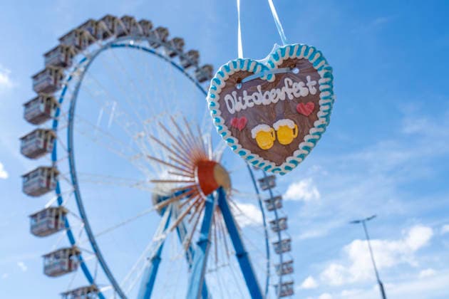 Lebkuchenherz Oktoberfest vor dem Riesenrad mit blauem Himmel, Souvenir zum Wiesnstart, Eröffnungstag, 19. September 2026 Deutschland, München, 19. September 2026, Oktoberfest 2026, Lebkuchenherz Oktoberfest vor dem Riesenrad mit blauem Himmel, Souvenir, Wiesn-Start bei strahlendem Sonnenschein und Temperaturen bis 24 Grad, mittags um 13:30, bestes Wiesnwetter, typisch bayerisch, Volksfest, Bayern,