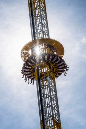 Oktoberfest 2026, die Sonne blinzelt durch das Fahrgeschäft Hangover, Wiesn-Start bei strahlendem Sonnenschein und Temperaturen bis 24 Grad, bestes Wiesnwetter, Eröffnungstag, 19. September 2026 Deutschland, München, 19. September 2026, Oktoberfest 2026, die Sonne blinzelt durch das Fahrgeschäft Hangover, ein Freifallturm mit 85 Metern Höhe, Wiesn-Start bei strahlendem Sonnenschein und Temperaturen bis 24 Grad, mittags um 13, kurz nach der Eröffnung, blauer Himmel, bestes Wiesnwetter, typisch bayerisch, Volksfest, Bayern,