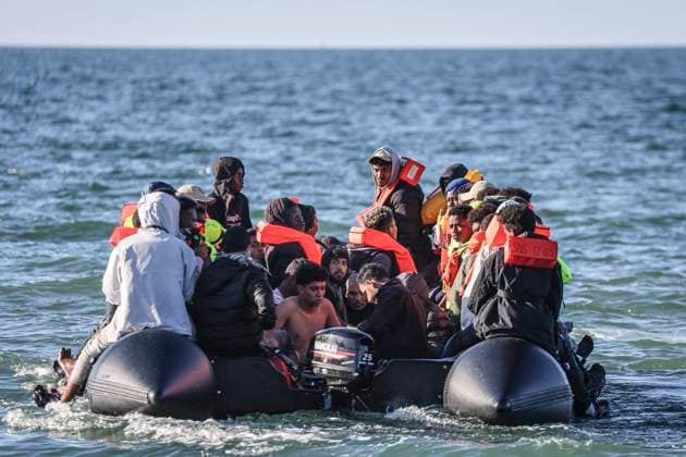 IMMIGRANTS EXILE SMALL BOAT PHOTOPQR WEST FRANCE Charles BURY MERVILLE FRANCEVILLE 09 21 2026 About fifty people seeking exile in a small boat, which had departed from Port-en-Bessin this morning, stopped at the beach in Merville-Franceville, escorted by the SNSM, to pick up a few people and then set off again for the British coast. Here in Merville-Franceville, Calvados, Normandy. Photo by Charles Bury, Ouest France. MERVILLE-FRANCEVILLE September 21, 2026. Around fifty people seeking to cross the Channel in a small boat—having set off from Port-en-Bessin this morning—stopped at the beach in Merville-Franceville under the escort of the SNSM, the French sea rescue service, to pick up a few more people before heading toward the British coas Copyright: xPHOTOPQR OUESTxFRANCE MAXPPPxCharlesxBURYx 20260921OFR7195 20260921OFR7195