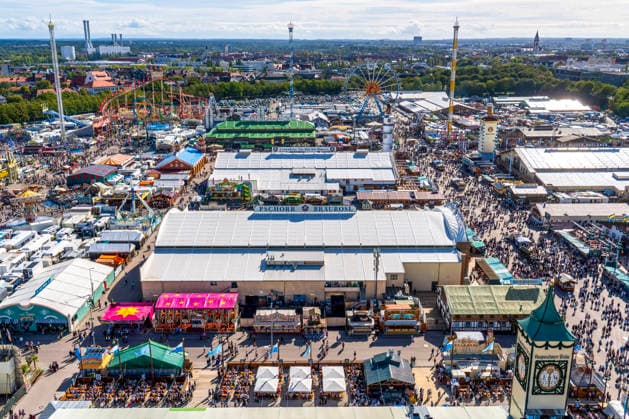 Oktoberfest 2026, Überblick über die Wiesn mit Riesenrad, Fahrgeschäft Hangover (rechts) und Festzelten bis nach München-Sendling, Sonnenschein bei 21 Grad, München, 21. September 2026 Deutschland, München, 21. September 2026, Überblick vom Skylift aus 91 Metern Höhe über die Wiesn mit Riesenrad, BayernTower (Mitte), Fahrgeschäft Hangover (rechts, gelb-weißer Tower) und Festzelten bis nach München-Sendling, 85 Meter hoher Freifalltower Hangover, Sonnenschein und Temperaturen bis 21 Grad, Mittwochnachmittag um 15 Uhr, freundliches Wiesnwetter mit Sonnenschein, typisch bayerisch, Oktoberfest 2026, Volksfest, Bayern,