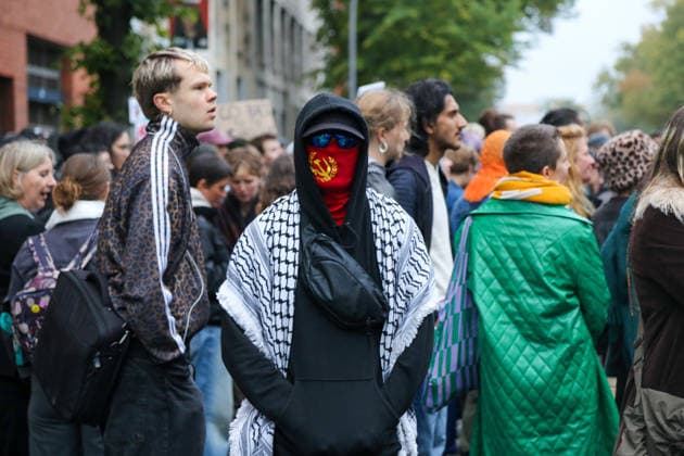 Berlin, Deutschland 24.09.2026: Vermummter Teilnehmer mit Kufiya bei der Protestkundgebung gegen die Verleihung des Axel Springer Awards an Peter Thiel. Das Gesicht ist mit einem roten Tuch mit kommunistischer Symbolik bedeckt. Demonstration, Protest, Peter Thiel, Palantir, Axel Springer Award, Vermummung, Kufiya, Palästinensertuch, Hammer und Sichel, Kommunismus, linke Szene, Aktivismus, Palästina, Nahost, Kundgebung. Copyright: xAlonxDavidx