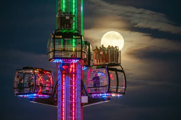 Der Vollmond, auch Erntemond genannt, leuchtet hinter dem SkyLift auf dem Oktoberfest, Wiesnbesucher in den Gondeln und auf der Freifläche machen Fotos mit ihren Smartphones, München, 26. September 2026 Deutschland, München, 26. September 2026, der Vollmond, auch Erntemond genannt, leuchtet hinter dem SkyLift auf dem Oktoberfest, Wiesnbesucher in den Gondeln und auf der Freifläche machen Fotos mit ihren Smartphones, Theresienwies, fast wolkenfreier Abendhimmel, um 19:25 Uhr, Bayern