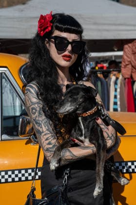 September 26, 2026, London, United Kingdom: An attendee at the King™s Cross Classic Car Boot Sale in London poses for photographs while holding her pet dog. The Kings Cross Classic Car Boot Sale returned to Granary Square and Stable Street, King™s Cross, London, for its 11th year. Held several times throughout the year, the event brings together vintage fashion, second-hand clothing, jewellery, homewares, collectables and vinyl records alongside classic cars, motorcycles and commercial vehicles. Visitors browsed stalls and traders, with many making a special effort to dress in period clothing inspired by the 1950s, 1960s and 1970s.continuing a tradition associated with the event. London United Kingdom - ZUMAs197 20260926_aaa_s197_370 Copyright: xJamesxWilloughbyx