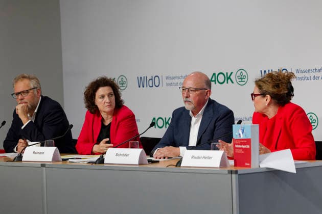 AOK-Fehlzeitenreport 2026 vorgestellt 2026-10-08 Deutschland, Berlin PressekonferenzFehlzeiten-Report 2026 des AOK-Bundesverbands und des Wissenschaftlichen instituts der AOK (WIsO). Im Bild v. l. Kai Behrens, AOK-Pressesprecher, Dr. Carola Reimann, Vorstandsvorsitzende AOK-Bundesverband, Helmut Schröder, Geschäftsführer des Wissenschaftlichen Instituts der AOK und Mitherausgeber des Reports, Prof. Dr. med. Steffi G. Riedel-Heller, MPH, Direktorin des Instituts für Sozialmedizin, Arbeitsmedizin unbd Publich Health der Universität Leipzig sowie Mit-Autorin des Fehlzeiten-Reports 2026.