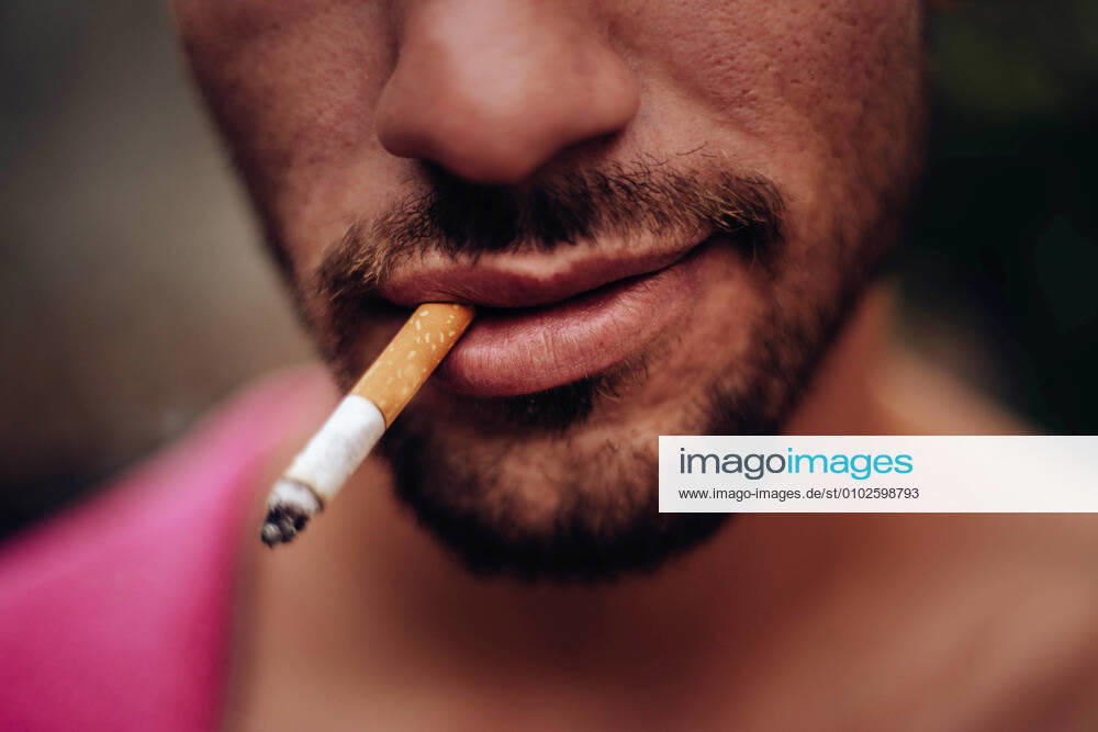 Mouth of a young man smiling while smoking a cigarette Madrid, Community of Madrid, Spain CR_DIRR200720A-447643-01 ,model released, Symbolfoto