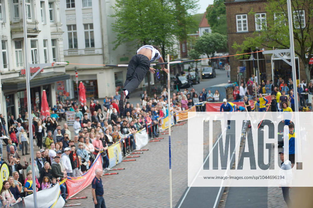 Flensburg, Schleswig-Holstein 1. Flensburger Marktplatzspringen, im Rahmen des Active City Festivals. Hier: Stabhochspringer beim Spung, er überwindet die Latte. Aufnahme vom 04.05.2024, Flensburg, Südermarkt