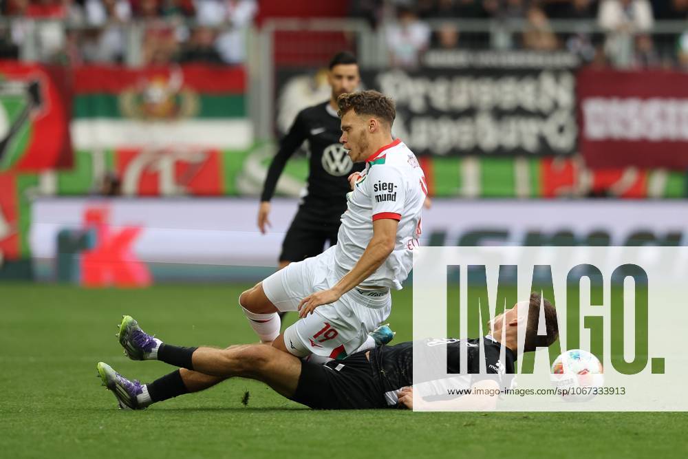 Im Zweikampf, Aktion, mit Robin Fellhauer 19 (FC Augsburg), Joakim Maehle 21 (VfL Wolfsburg), FC Augsburg vs. VfL Wolfsburg, Fussball, 1. Bundesliga, 6. Spieltag, 04.10.2025 DFB regulations prohibit any use of photographs as image sequences and or quasi-video Augsburg Bayern Deutschland