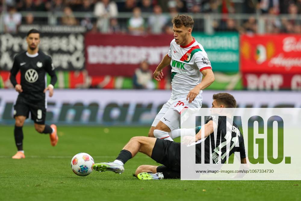Im Zweikampf, Aktion, mit Robin Fellhauer 19 (FC Augsburg), Joakim Maehle 21 (VfL Wolfsburg), FC Augsburg vs. VfL Wolfsburg, Fussball, 1. Bundesliga, 6. Spieltag, 04.10.2025 DFB regulations prohibit any use of photographs as image sequences and or quasi-video Augsburg Bayern Deutschland