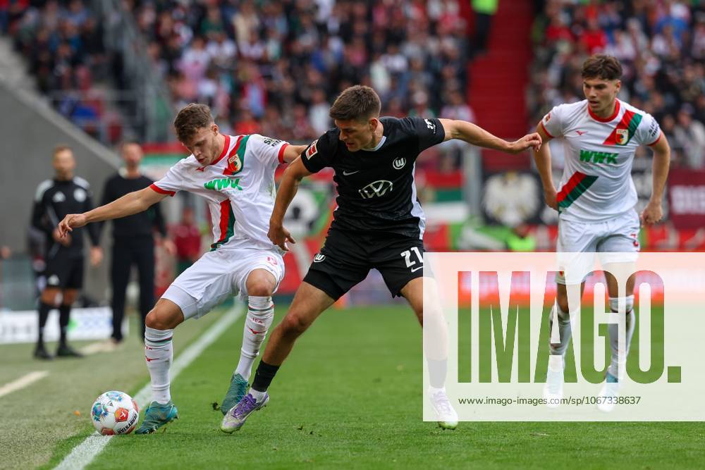 Im Zweikampf, Aktion, mit Robin Fellhauer 19 (FC Augsburg), Joakim Maehle 21 (VfL Wolfsburg), Mert Koemuer 36 (FC Augsburg), FC Augsburg vs. VfL Wolfsburg, Fussball, 1. Bundesliga, 6. Spieltag, 04.10.2025 DFB regulations prohibit any use of photographs as image sequences and or quasi-video Augsburg Bayern Deutschland