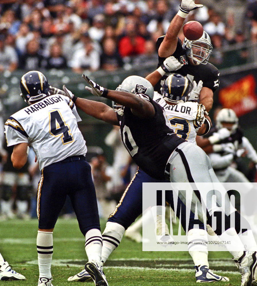 Oakland, California, U.S - Oakland Raiders vs. San Diego Chargers at Oakland Alameda County Coliseum Sunday, November 14, 1999. Raiders beat Chargers 28-9. San Diego Chargers guard Aaron Taylor (73) blocks Oakland Raiders linebacker Greg Biekert (54) as quarterback Jim Harbaugh (4) attempts to pass ball over his head.