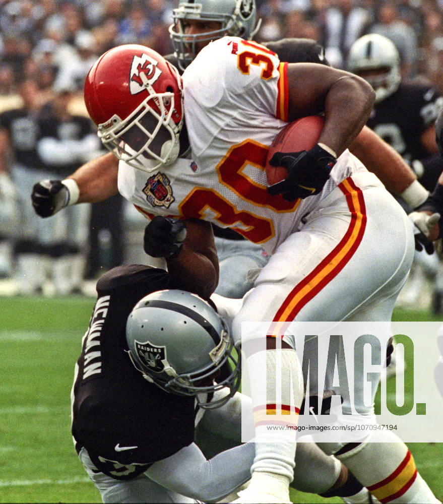 Oakland, California, U.S - Oakland Raiders vs. Kansas City Chiefs at Oakland Alameda County Coliseum Sunday, November 29, 1999. Chiefs beat Raiders 37-34. Oakland Raiders defensive back Anthony Newman (30) tackles Kansas City Chiefs running back Donnell Bennett