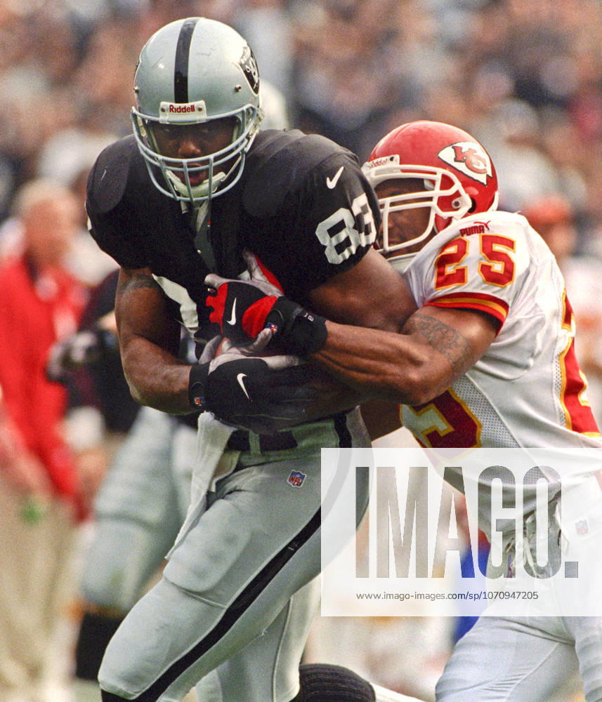 Oakland, California, U.S - Oakland Raiders vs. Kansas City Chiefs at Oakland Alameda County Coliseum Sunday, November 29, 1999. Chiefs beat Raiders 37-34. Kansas City Chiefs defensive back Reggie Tonque (25) tackles Oakland Raiders tight end Rickey Dudley
