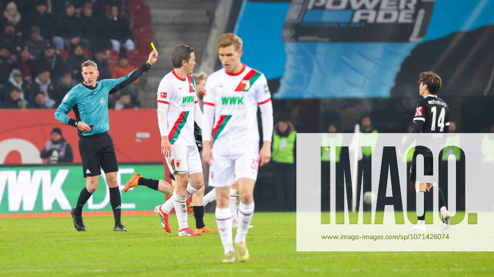 Martin Petersen (Schiedsrichter) zeigt Yuito Suzuki (14, SC Freiburg), die gelbe Karte beim Spiel zwischen FC Augsburg v SC Freiburg, Fußball, Herren, Bundesliga, 2025 2026, 18.Spieltag am 18.01.2026 in Augsburg, WWK-Arena. DFL and DFB regulations prohibit any use of photographs as image sequences and or quasi-video. Bayern Deutschland
