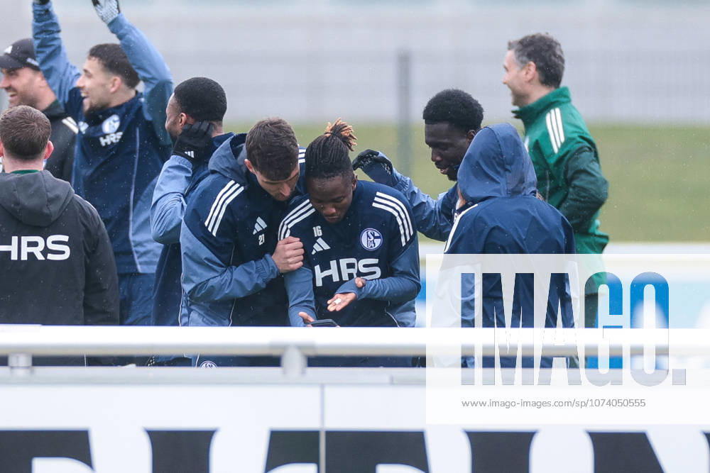 Fussball; Training des FC Schalke 04. v. l. Dejan Ljubicic (FC Schalke 04), Moussa Ndiaye (FC Schalke 04), Zaid Tchibara (FC Schalke 04) schuiaen sich etwas auf dem Smartphone an. Gelsenkirchen Trainingsgelände FC Schalke 04 NRW Deutschland xRHR-FOTO YYx