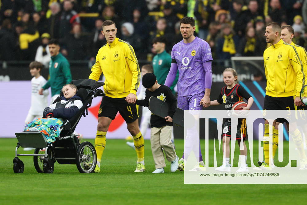 Dortmund, Germany, 14.03.26, Nico Schlotterbeck (Borussia Dortmund) , Gregor Kobel (Borussia Dortmund) und Waldemar Anton (Borussia Dortmund) mit Einlaufkind während des Spiels der 1. Bundesliga zwischen Borussia Dortmund - FC Augsburg im Signal Iduna Park in Dortmund. (Photo by Joachim Bywaletz) DFB DFL REGULATIONS PROHIBIT ANY USE OF PHOTOGRAPHS AS IMAGE SEQUENCES AND OR QUASI-VIDEO.