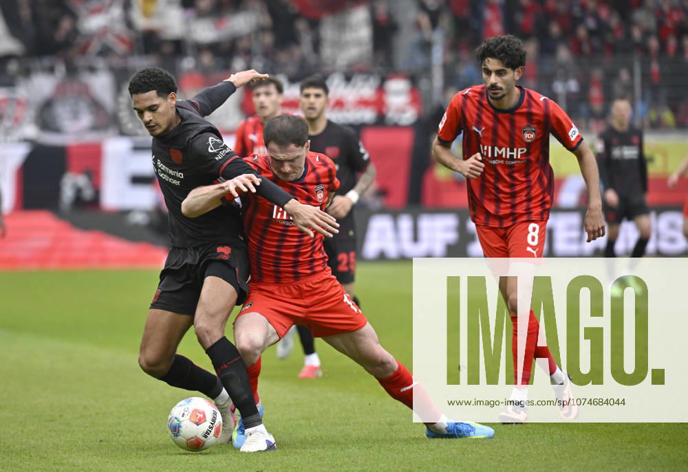 Zweikampf, Aktion Budu Zivzivadze Siwsiwadse 1. FC Heidenheim 1846 FCH (11) gegen Jarell Quansah Bayer 04 Leverkusen (04) Eren Dinkci 1. FC Heidenheim 1846 FCH (08) 1. FC Heidenheim 1846 FCH vs Bayer 04 Leverkusen B04 21.03.2026 DFL REGULATIONS PROHIBIT ANY USE OF PHOTOGRAPHS AS IMAGE SEQUENCES AND OR QUASI-VIDEO 1. FC Heidenheim 1846 FCH vs Bayer 04 Leverkusen