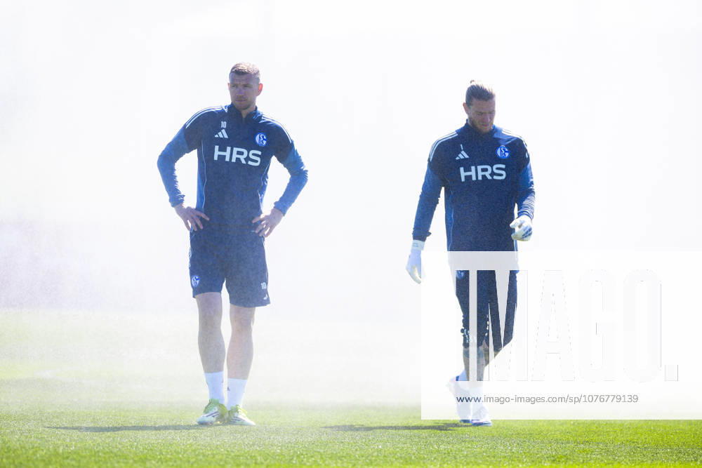 Fussball, Training des FC Schalke 04. v. l. Edin Dzeko (FC Schalke 04). Torwart Loris Karius (FC Schalke 04) stehen im Nebel der Sprinkleranlage. Gelsenkirchen Trainingsgelände FC Schalke 04 NRW Deutschland xRHR-FOTO YYx