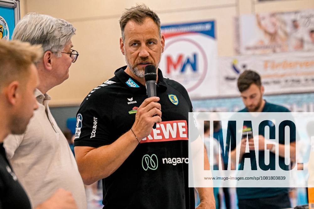 Maik Machulla, Offizieller der Rhein Neckar Löwen, spricht beim DHB-Pokal-Spiel zwischen Rein Neckar Löwen und SV Salamander Kornwestheim am 21.08.2026 in der Sporthalle Ost Kornwestheim ins Mikrofon. Der Funktionär trägt das schwarze Vereins-Outfit mit Sponsorenlogos (SAP, REWE, nagaro) und adressiert die anwesenden Zuschauer und Mannschaftsmitglieder. Maik Machulla spricht bei DHB-Pokal-Event in Kornwestheim