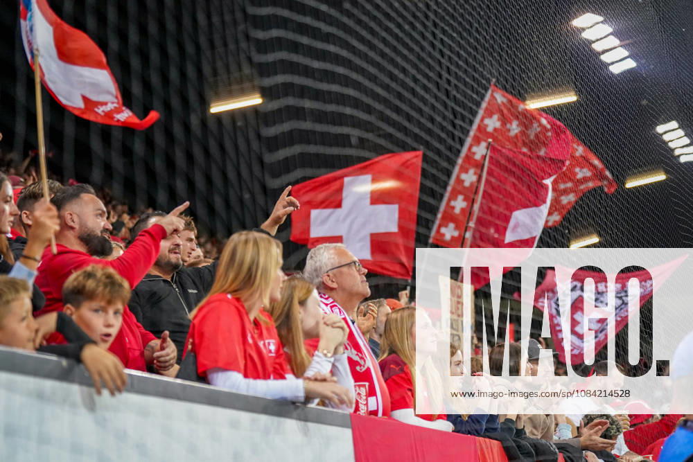 Fussball UEFA Nations League 2026 - 2027, 4. Spieltag - Schweiz vs Nordmazedonien - Thermoplan Arena (Luzern): Schweizer Fans schwenken National- und Fanflaggen auf der Tribüne beim UEFA-Nations-League-Spiel Schweiz gegen Nordmazedonien in Luzern. Schweizer Fans, Fans, Supporter, Fankultur, Fanblock, Zuschauer, Stimmung, Schweizer Fahne, Schweizer Flagge, Nationalflagge, Fanflaggen, Schweiz, Nordmazedonien, UEFA Nations League, Luzern, Thermoplan Arena, Länderspiel