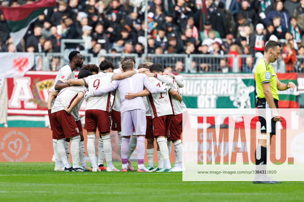 Team (FC Augsburg), Spielerkreis im Vordergrund, Sven Jablonski (Schiedsrichter:in) beim Spiel zwischen FC Augsburg v FC Bayern München, Fussball, Herren, Bundesliga, 2026 2027, 5.Spieltag am 10.10.2026 in Augsburg, WWK ARENA. DFL and DFB regulations prohibit any use of photographs as image sequences and or quasi-video. Bayern Deutschland
