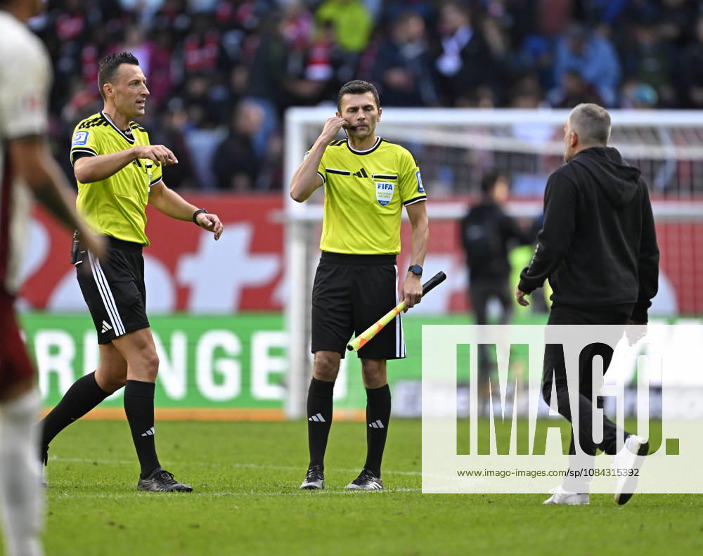 Fussball Bundesliga 2026 2027, 5.Spieltag, FC Augsburg - FC Bayern München, in der WWK-Arena Augsburg, Trainer Manuel Baum (FC Augsburg) rennt in der Halbzeitpause zu Schiedsrichter Sven Jablonski (Deutschland)