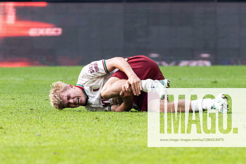 Deutschland: FC Augsburg vs FC Bayern München, 1. Bundesliga, 5. Spieltag, Saison 2026 27, WWK Arena (Augsburg): Hennes Behrens, (FC Augsburg, 16) mit schmerzen am Boden Augsburg WWK Arena Bayern Deutschland
