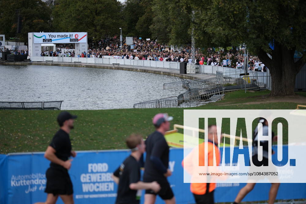 Munich Marathon 2026 MUNICH, GERMANY - OCTOBER 11: Runners pass along a course beside a lake as a large crowd of spectators gathers near the finish line in the background during the 2026 Munich Marathon in Munich, Germany on October 11, 2026. The finish line, marked with a You made it! banner, is set within the Olympic Park. Merve Goettl Anadolu Munih Germany. Editorial use only. Please get in touch for any other usage.