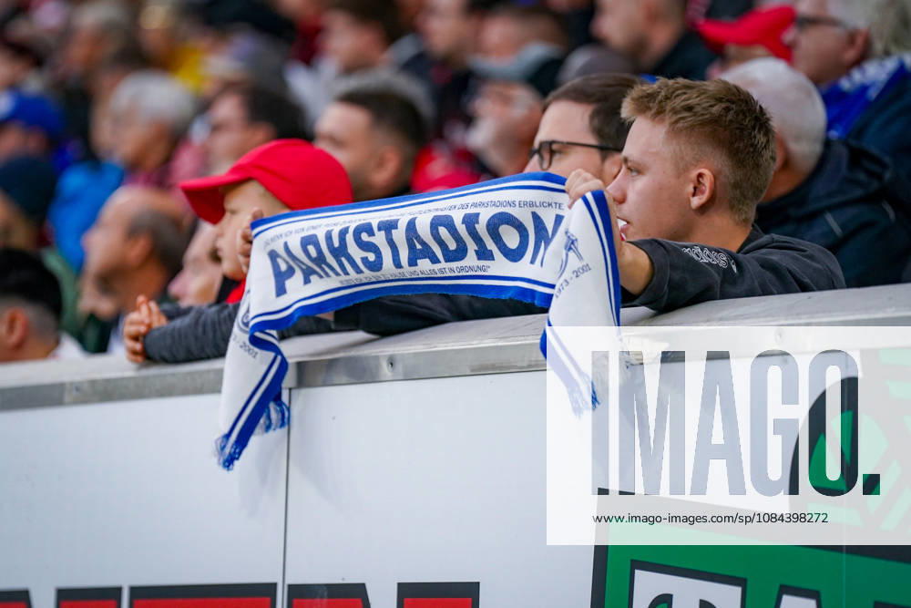 Deutschland: Fußball Bundesliga 2026 - 2027, 5. Spieltag - SC Freiburg - FC Schalke 04 - Europa-Park-Stadion (Freiburg): Junger Fan des FC Schalke 04 hält einen blau-weissen Fanschal mit der Aufschrift PARKSTADTION auf der Tribüne des Europa-Park Stadions beim Auswärtsspiel gegen den SC Freiburg hoch. Schalke 04, S04, Königsblau, Parkstadion, Stadiongeschichte, Tradition, Nostalgie, Fankultur, Fanszene, Gästefans, Auswärtsfans, Fanschal, Fanartikel, Zuschauer, Tribüne, Fussball, Bundesliga, SC Freiburg, SCF, Gelsenkirchen, Freiburg, Stadion, Innenansicht, Detailaufnahme.