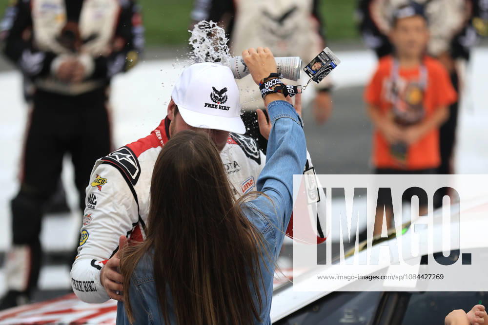 CHARLOTTE, NC - OCTOBER 11: Chase Briscoe ( 19 Joe Gibbs Racing Freebird Spring Water Toyota) celebrates as his wife Marissa pours water on his head after winning the NASCAR, Motorsport, USA Cup Series Playoffs Bank of America 400 race on October 11, 2026 at Charlotte Motor Speedway in Charlotte, NC. (Photo by Jeff Robinson Icon Sportswire) AUTO: OCT 11 NASCAR Cup Series Playoffs Bank of America 400 Icon2610111024400