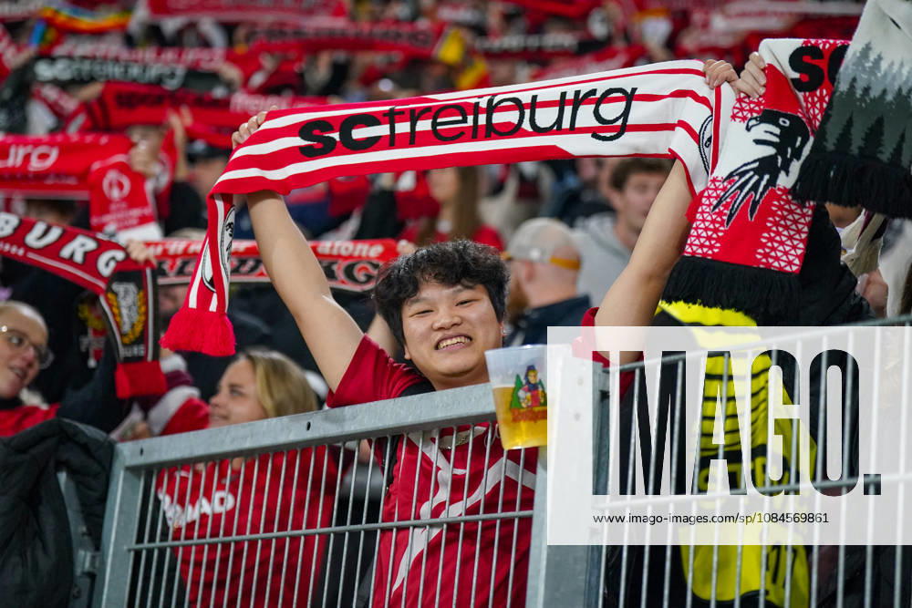 Deutschland: Fussball UEFA Conference League 2026 - 2027, 1. Spieltag - SC Freiburg vs FK Jablonec - Europa-Park-Stadion (Freiburg): Lächelnder Fan des SC Freiburg hält einen rot-weissen Fanschal mit der Aufschrift scfreiburg über den Kopf. Porträt eines begeisterten Anhängers auf der Tribüne des Europa-Park-Stadions beim UEFA Conference League-Spiel gegen FK Jablonec. SC Freiburg, FK Jablonec, Fussball, Europapokal, Fussballfan, Fans, Zuschauer, Fankultur, Fanschal, Vereinsfarben, Vereinswappen, Fanartikel, Merchandising, Emotionen, Begeisterung, Heimfans, Stadion, Tribüne, Supporter, Fanblock.