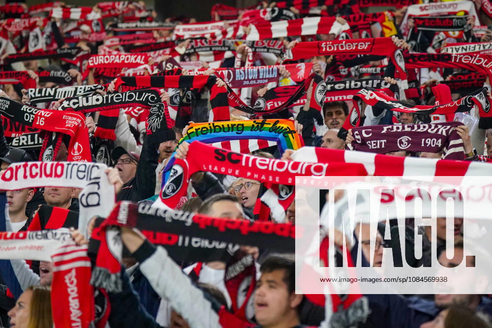 Deutschland: Fussball UEFA Conference League 2026 - 2027, 1. Spieltag - SC Freiburg vs FK Jablonec - Europa-Park-Stadion (Freiburg): Fans des SC Freiburg halten auf der Tribüne des Europa-Park-Stadions zahlreiche rot-weisse und schwarz-rote Fanschals in die Höhe. Geschlossenes Fanbild beim UEFA Conference League-Spiel gegen FK Jablonec. Sichtbar ist auch ein Regenbogenschal mit der Aufschrift Freiburg ist bunt. SC Freiburg, FK Jablonec, Fussball, Europapokal, Fans, Zuschauer, Fankultur, Fanblock, Fanschals, Vereinsfarben, Solidarität, Vielfalt, Diversität, Toleranz, LGBTQ, Stimmung, Heimfans, Supporter, Fanartikel, Stadion.